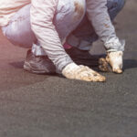 Group of worker installing tar foil on the rooftop of building. Waterproof system by gas and fire torching